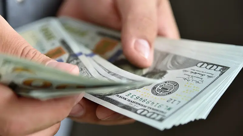 Close up of businessman counts money in hands. Financial success and wealth concept.