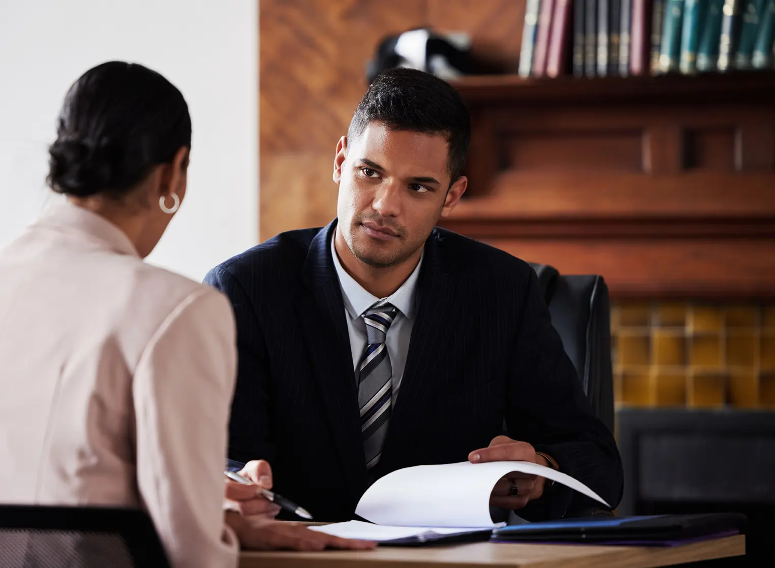 Contract, signature and attorney consulting a client in his office with legal paperwork or agreement. Signature, approval and male lawyer in discussion with woman with a document to sign in workplace.