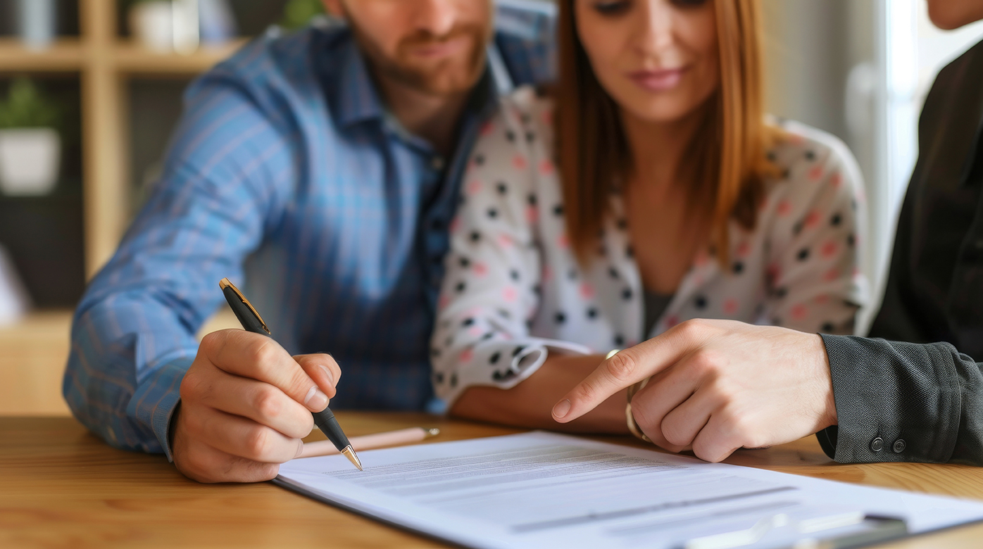 Happy young couple signing bank loan agreement with real-estate agent to buying the house in office. People sign Insurance, mortgage or business deal agreement. Legal contract document. Man hold pen.