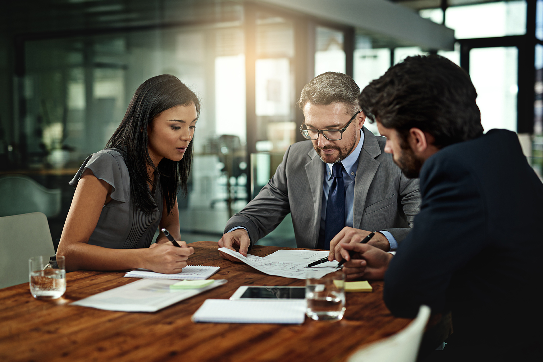 Businesspeople, deal and meeting with documents in boardroom, office and sign for corporate b2b sale. Collaboration, attorney with paperwork and contract, management and planning for negotiation.