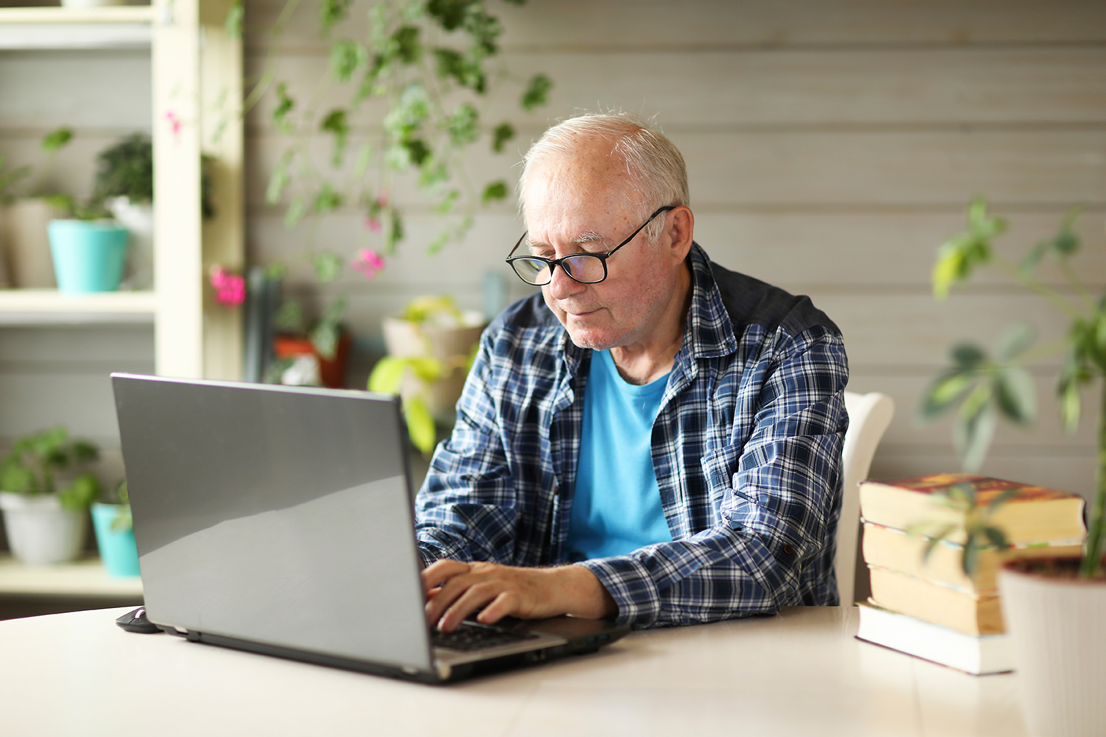 elderly man working on computer while sitting at home. High quality photo